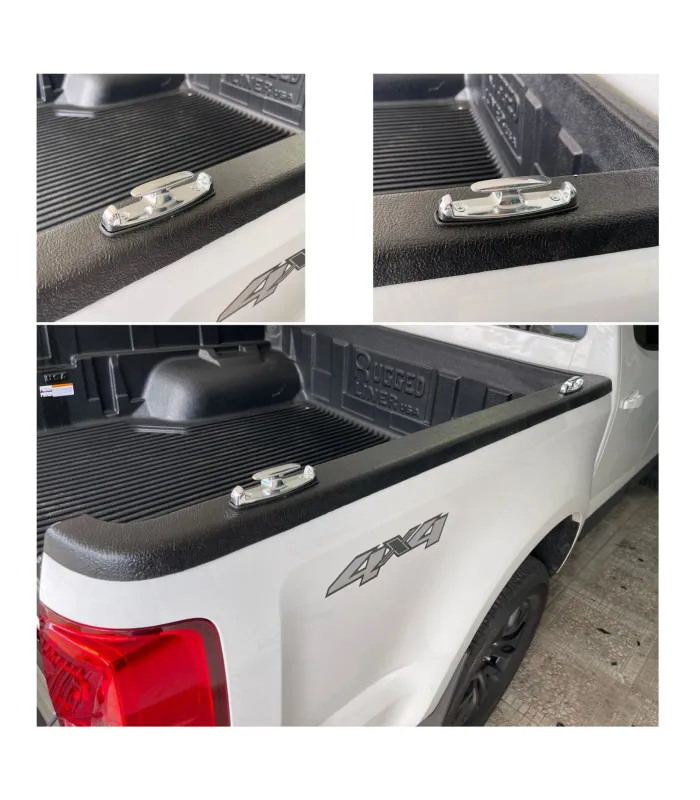 Gancho de amarre metálico de color cromado instalado en el riel de una cama de camioneta.