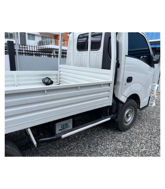 Estribo lateral de acero color negro instalado en un camión Isuzu Traviz para facilitar el acceso a la cabina.