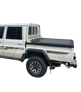 Vista de tres cuartos trasera de la Land Cruiser con la tapa de cama cerrada, mostrando la integración de la adaptación