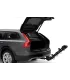 Usuario inclinando el Thule Apex XT 4 para acceder al baúl del vehículo